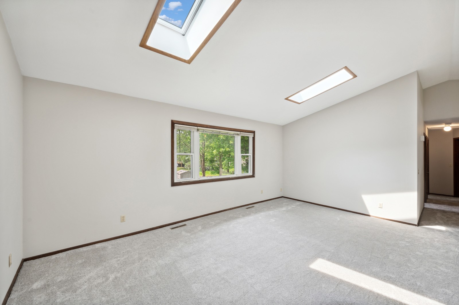 Cozy living room at Blossom Hill Assisted Living in Woodbury, MN, with comfortable seating, high ceilings, and a large window for natural light